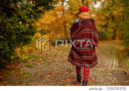 Seen from behind woman in red hat walking Seen from behind woman in red hat walking 130250378