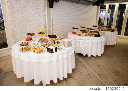 Elegant buffet table with assorted appetizers and desserts at a formal event 130250942