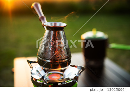 Cezve Heats Water On A Portable Gas Stove During Outdoor Summer Rest Cezve Heats Water On A Portable Gas Stove During Outdoor Summer Rest 130250964