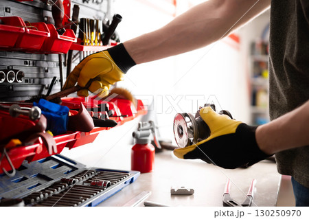 Auto Mechanic Checking Auto Part With Tools At The Service Center Table 130250970
