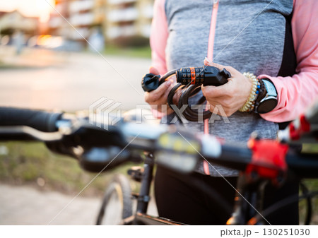 Girl With Code Bike Lock In Hands On A Bicycle Parking 130251030