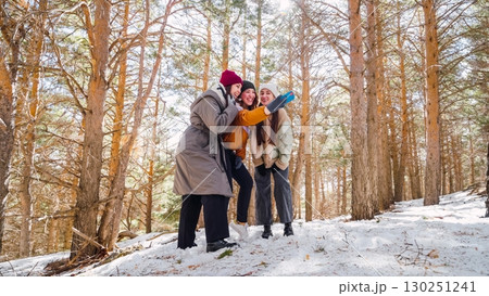 Three smiling women taking selfie in snowy forest 130251241