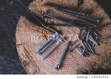 Fasteners for wood. Self-tapping screws on a wooden table. Fasteners for wood. Self-tapping screws on a wooden table. 130251413