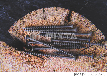 Fasteners for wood. Self-tapping screws on a wooden table. Fasteners for wood. Self-tapping screws on a wooden table. 130251429