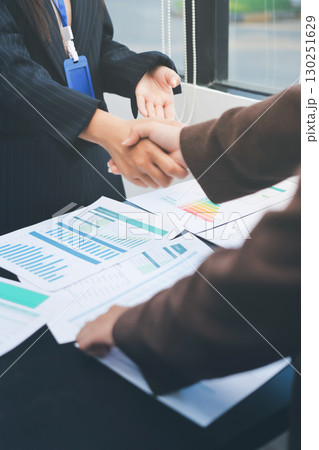 Business people shaking hands in office. Two business partners shaking hands after signing a contract in office. Business people shaking hands in office. Two business partners shaking hands after signing a contract in office. 130251629