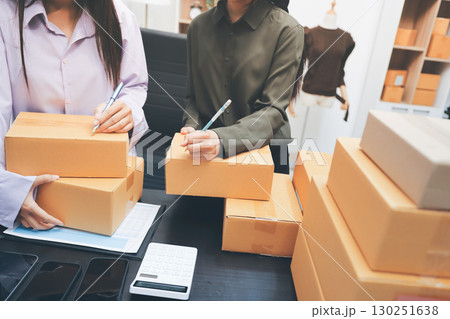 Portrait of Starting small businesses SME owners, two Asian woman check online orders Selling products working with boxs freelance work at home office, sme business online small medium enterprise Portrait of Starting small businesses SME owners, two Asian woman check online orders Selling products working with boxs freelance work at home office, sme business online small medium enterprise 130251638