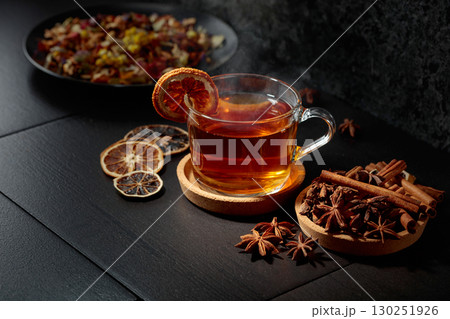 Cup of herbal tea with ingredients and slices of dried orange slices. 130251926