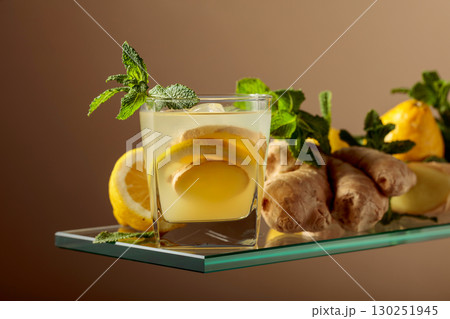 Ginger cocktail with lemon and mint in a frozen glass. Ginger cocktail with lemon and mint in a frozen glass. 130251945