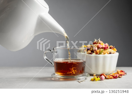Herbal tea is poured into a glass mug. Herbal tea is poured into a glass mug. 130251948