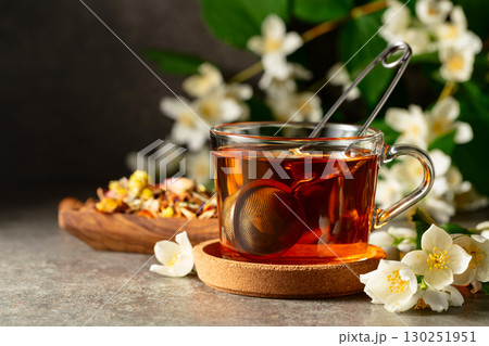 Cup of jasmine tea and fresh jasmine flowers on a stone table. Cup of jasmine tea and fresh jasmine flowers on a stone table. 130251951