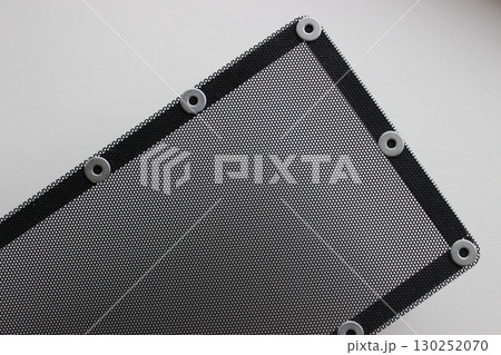 Pattern of protective grill with small round holes and mounting bracket on the frame isolated on white 130252070