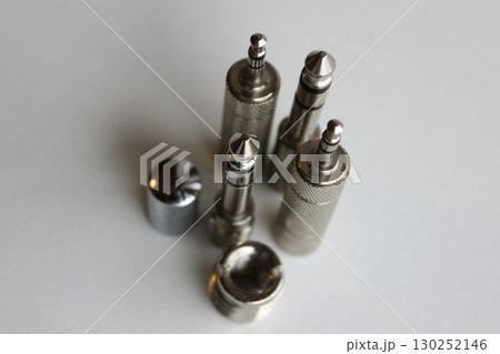 Audio Equipment. Set of metal adapters from 3.5mm plug to 6.35mm plug top view Audio Equipment. Set of metal adapters from 3.5mm plug to 6.35mm plug top view 130252146