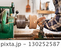 Carpentry. Turnery of a wooden bowl with spiral sawdust shavings with hand and chisel 130252587
