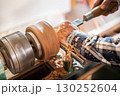 Carpentry. Turnery of a wooden bowl with spiral sawdust shavings with hand and chisel 130252604