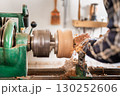 Carpentry. Turnery of a wooden bowl with spiral sawdust shavings with hand and chisel 130252606