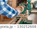 Carpentry. Turnery of a wooden bowl with spiral sawdust shavings with hand and chisel 130252608
