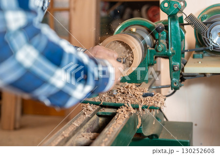 Carpentry. Turnery of a wooden bowl with spiral sawdust shavings with hand and chisel 130252608