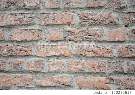 Brown and gray structural stone wall of the ancient building consists of bricks. Nature structural background. 130252617