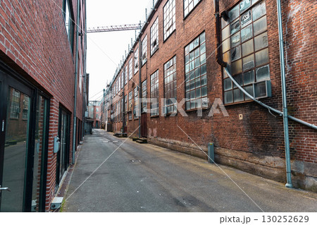 Old red brick factory building with large windows 130252629