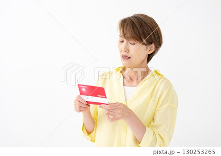 通帳を見て悩むミドル女性　 130253265