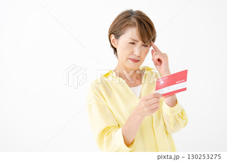 通帳を見て悩むミドル女性 通帳を見て悩むミドル女性 130253275