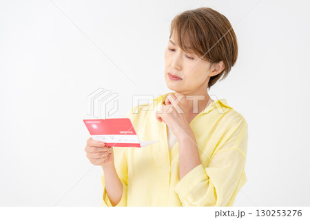 通帳を見て悩むミドル女性 通帳を見て悩むミドル女性 130253276