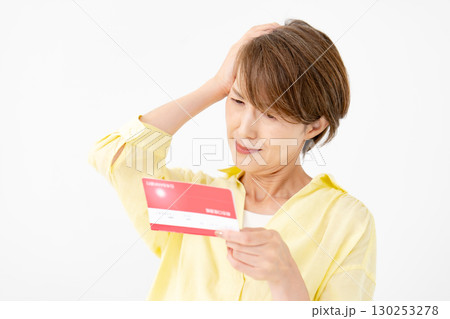 通帳を見て悩むミドル女性　 130253278