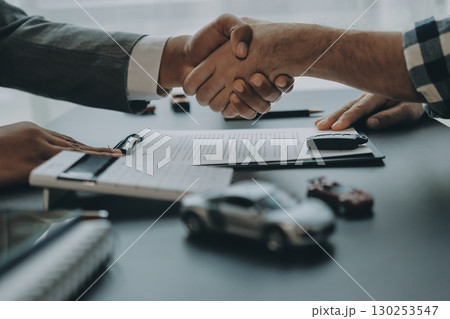 Car salesman gave the keys to the customers who signed the purchase contract legally, Successful completion of car sales, Purchase contract and key delivery. Car salesman gave the keys to the customers who signed the purchase contract legally, Successful completion of car sales, Purchase contract and key delivery. 130253547