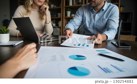 Business Meeting with Charts and Graphs on Table in Modern Office Setting 130254881