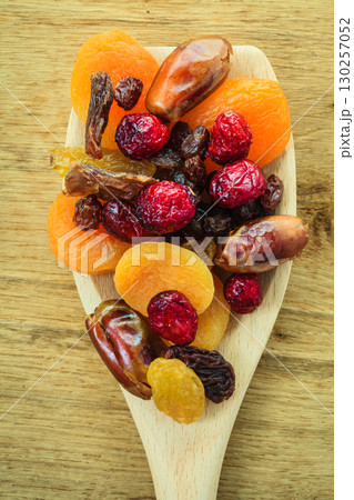 Varieties of dried fruits on wooden spoon. 130257052