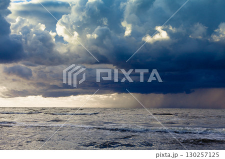 Beginning of the storm rain in ocean, dark cloudy sky 130257125