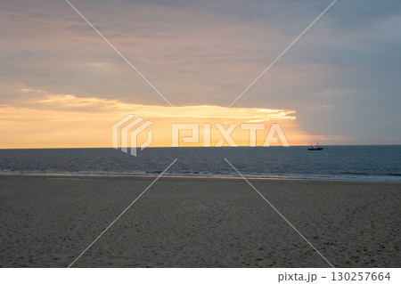 Sunset on the beach near beautiful sea in the evening. Boat and yellow sunlight. Vacation in Ostend, Belgien. 130257664