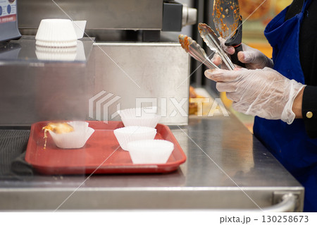 スーパーの試食コーナーで食品を取り分ける女性の手元 スーパーの試食コーナーで食品を取り分ける女性の手元 130258673