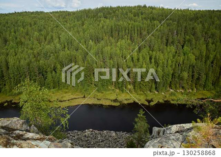 Enjoy the stunning view of a lush forest and a calm river from a beautiful hilltop 130258868