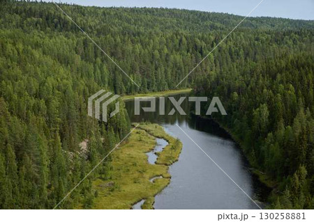 A Serene and Picturesque River Gently Flowing Through a Lush Green Forested Landscape 130258881