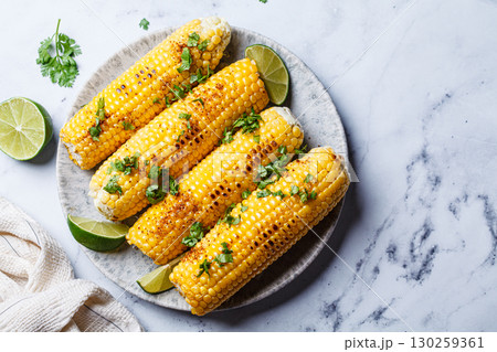 Grilled corn with cilantro, spices and butter. 130259361