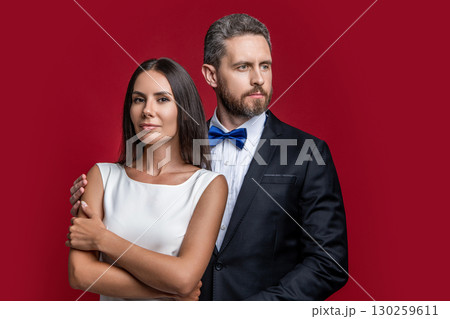 Formal couple. Couple in formal wear. Man and woman in luxury suit. Elegant style date. Romantic woman with elegant man isolated on red. Couple in love. Valentines day occasion. Special occasion Formal couple. Couple in formal wear. Man and woman in luxury suit. Elegant style date. Romantic woman with elegant man isolated on red. Couple in love. Valentines day occasion. Special occasion 130259611