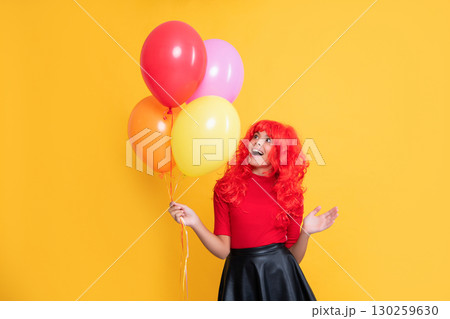 amazed teen girl with party balloon on yellow background amazed teen girl with party balloon on yellow background 130259630
