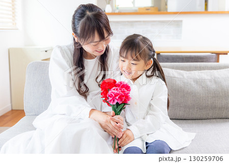 カーネーションの花束を渡す女の子 130259706