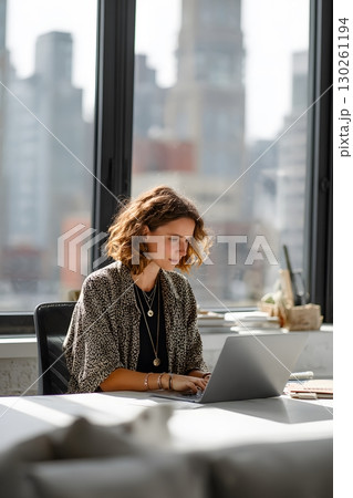 female startup founder typing on laptop in bright modern office 130261194