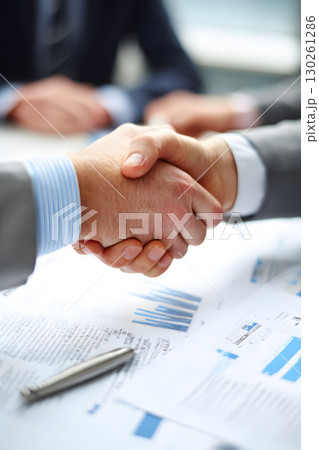 professional collaboration shown by handshake near business documents 130261286