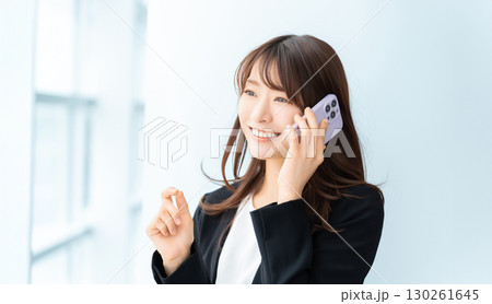 スマートフォンで話す笑顔の女性・ビジネスウーマン スマートフォンで話す笑顔の女性・ビジネスウーマン 130261645