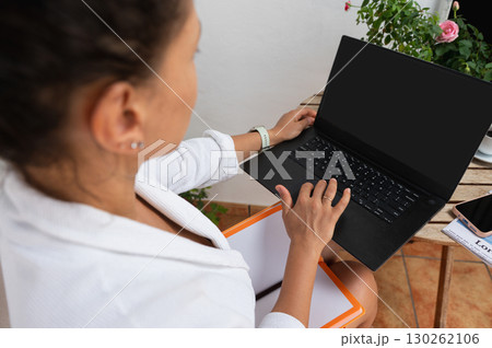 Woman Working Remotely on Laptop at Outdoor Workspace 130262106