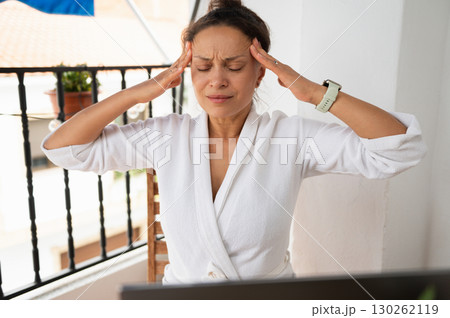 Woman Experiencing Headache While Working at Home in Comfortable Attire 130262119