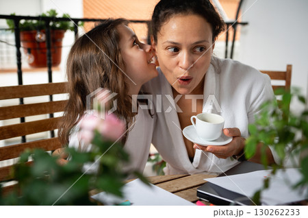 Mother and Daughter Sharing a Secretive Moment Over Morning Coffee on Balcony Mother and Daughter Sharing a Secretive Moment Over Morning Coffee on Balcony 130262233