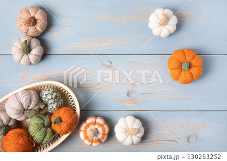 Cozy composition for needlework from basket with balls for knitting warm clothes and knitted pumpkin toys. Cozy composition for needlework from basket with balls for knitting warm clothes and knitted pumpkin toys. 130263252