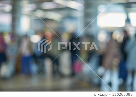 Blurred image of diverse travelers in busy airport terminal setting 130263399