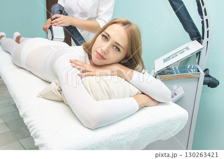 Caucasian young female relaxing during spa treatment session with modern beauty Caucasian young female relaxing during spa treatment session with modern beauty 130263421
