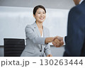 笑顔で握手するビジネスウーマン 130263444