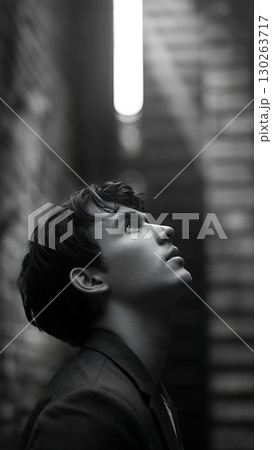 A Dramatic Black and White Portrait of a Young Man Looking Up 130263717